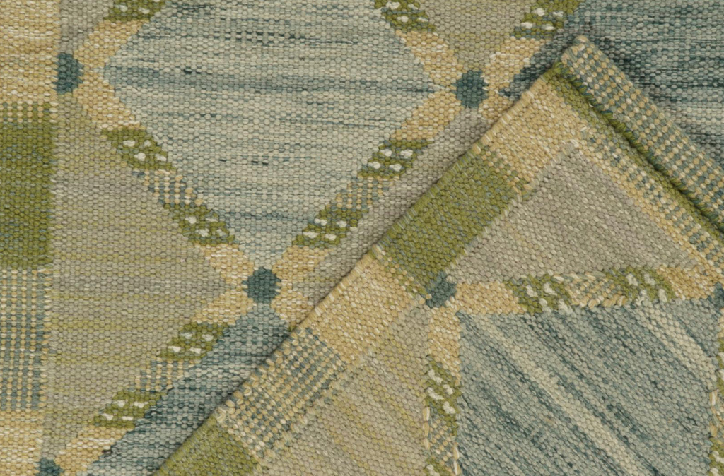 Close-up of a textured fabric with geometric pattern in green and beige tones.