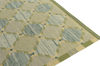 Geometric patterned rug with green and beige colors on a white background