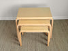 Set of three light wood nesting tables on a carpeted floor.