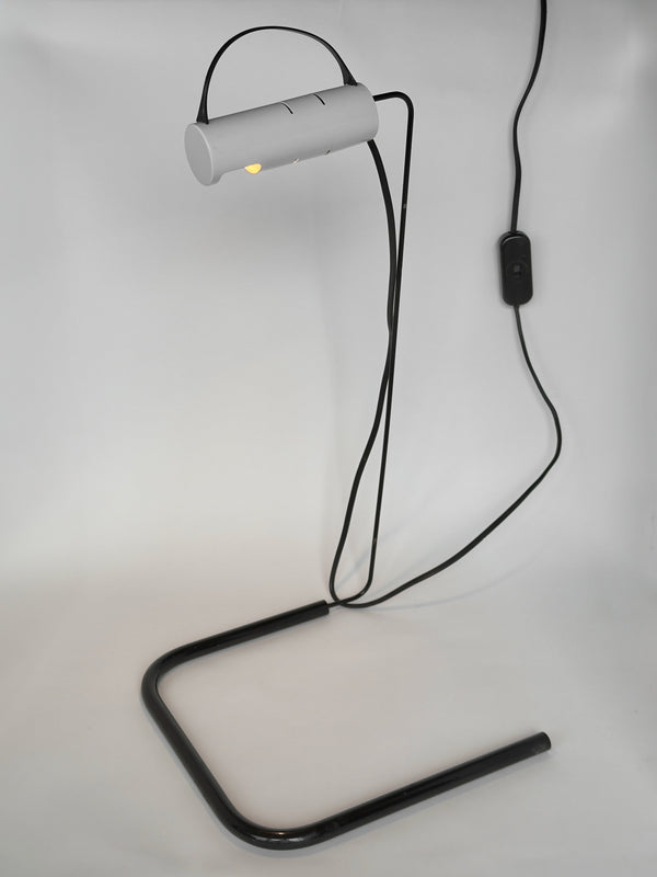 Modern desk lamp with black metal stand and white cylindrical light fixture on a light gray background