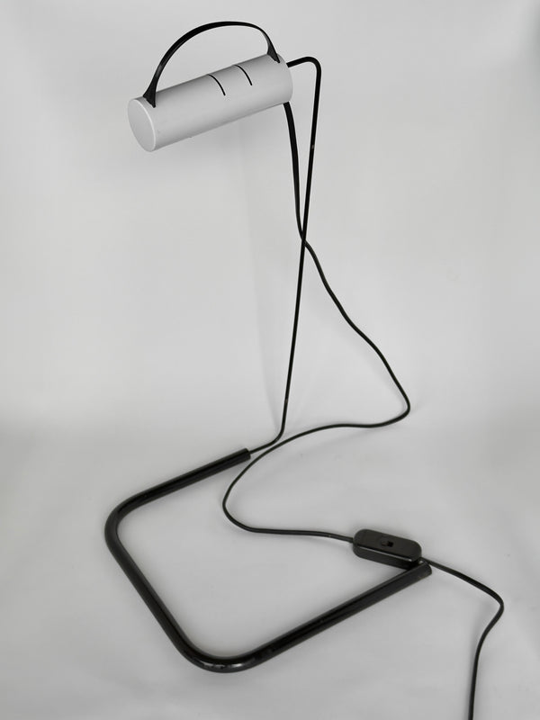 Modern desk lamp with a white cylindrical shade and black metal base on a light gray background