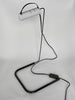 Modern desk lamp with a white cylindrical shade and black metal base on a light gray background
