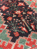 Close-up of a patterned fabric with red, green, and black colors. Tapestry art