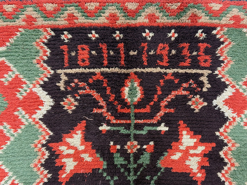 Close-up of a woven textile with decorative patterns and the year 1811 1936.
