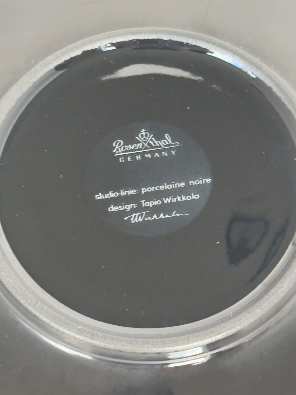 Round black object with a brand label on a white background