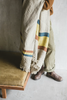 Person wearing a striped linen blanket draped over their shoulders