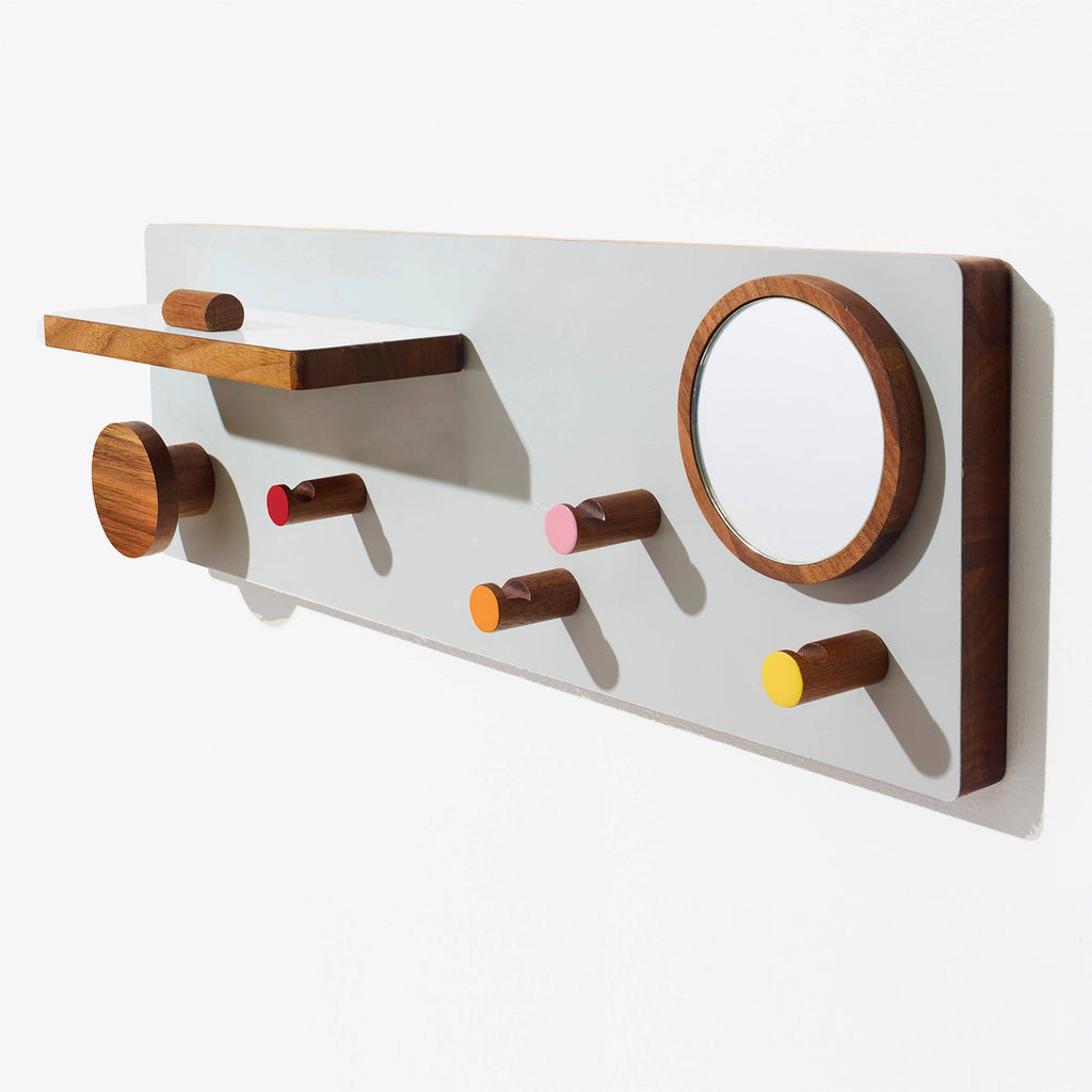 Wall-mounted coat rack with wooden hooks and a round mirror on a white background