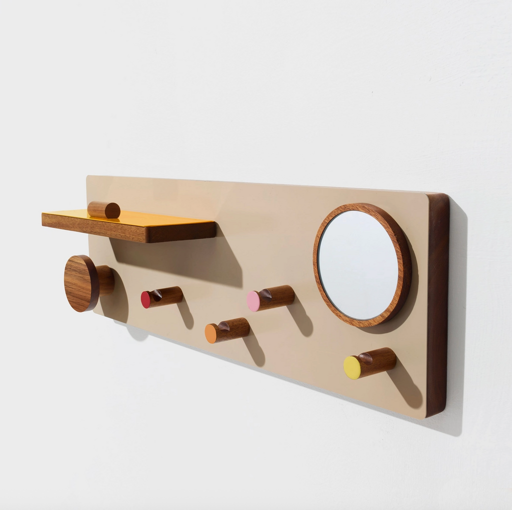 Wooden wall-mounted shelf with hooks and a small mirror on a white background