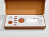 Open box containing wooden control panel components and instructions on a white background