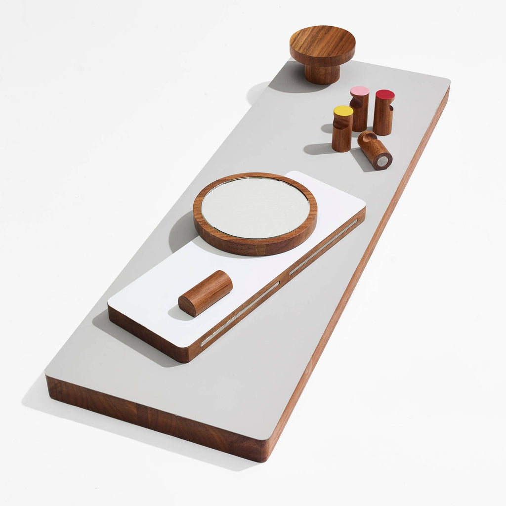 Wooden and white geometric table with cylindrical objects on a white background