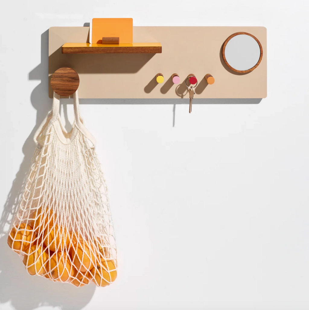 Wall-mounted wooden organizer with hooks and a shelf on a white background