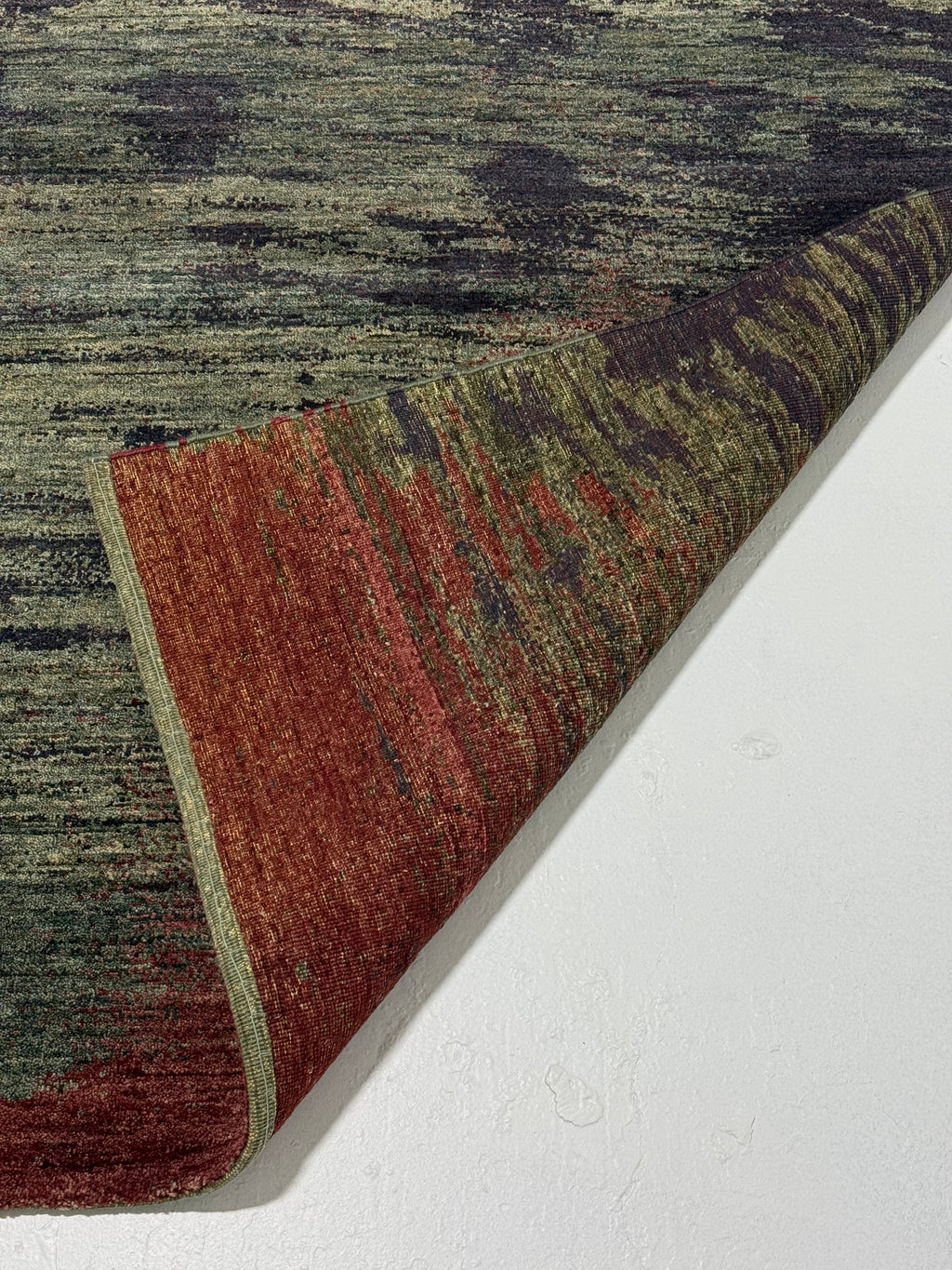 Textured area rug with a mix of colors on a white floor.