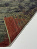 Textured area rug with a mix of colors on a white floor.