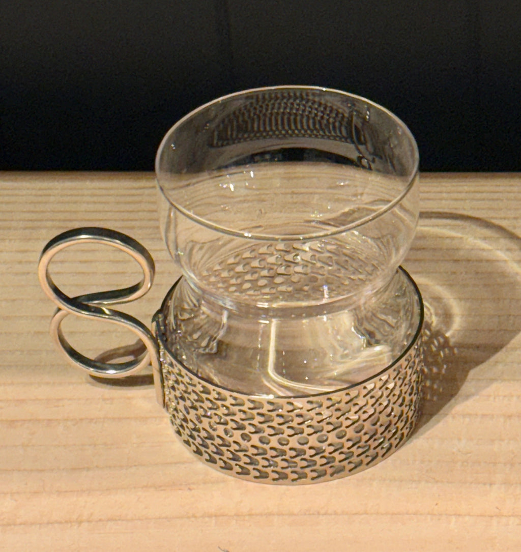 Clear glass mug with textured base on a wooden surface