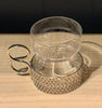Clear glass mug with textured base on a wooden surface