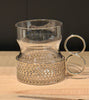 Decorative glass holder with metallic base on a wooden surface