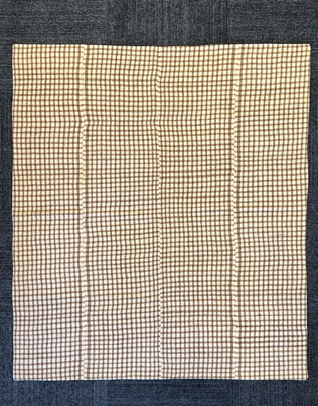 Checkered wool rug on a denim background