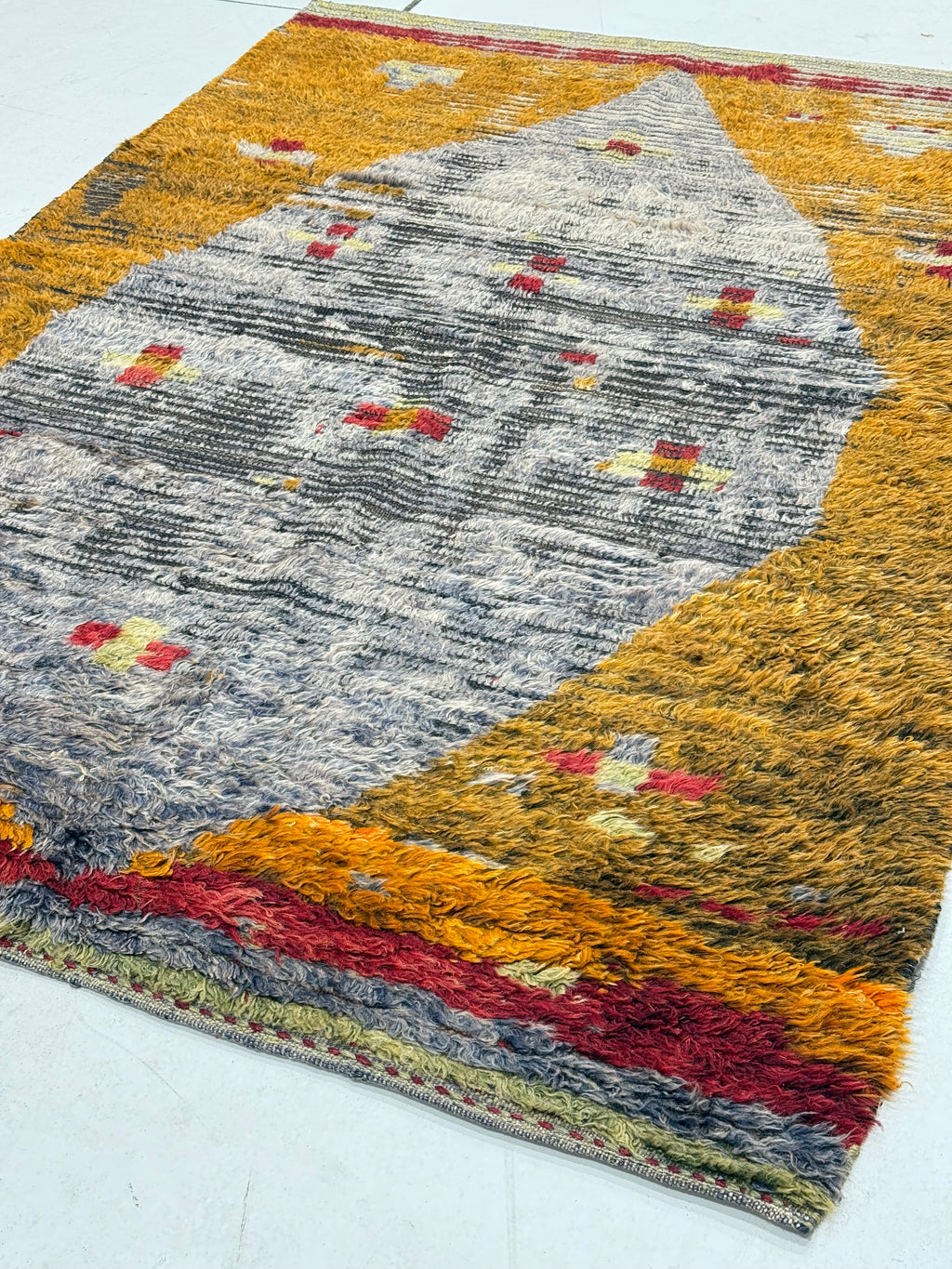 Multicolored textured rug with geometric pattern on a white background