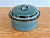Teal ceramic pot with lid on a wooden surface