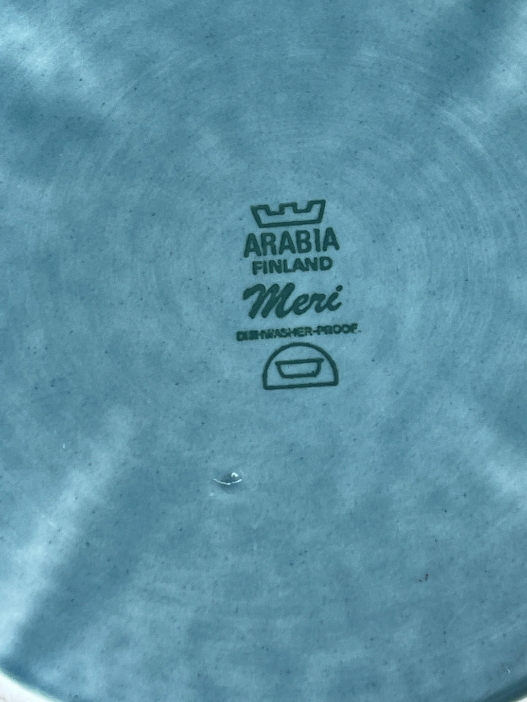 Close-up of a textured surface with 'Arabia Finland Meri' branding.
