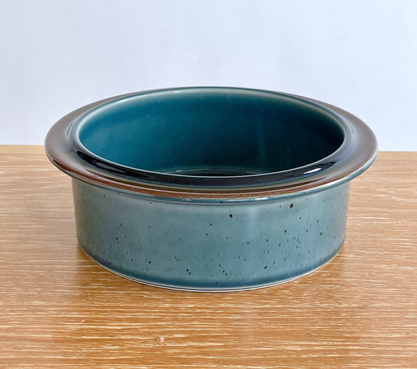 Blue ceramic bowl on a wooden surface with a white background