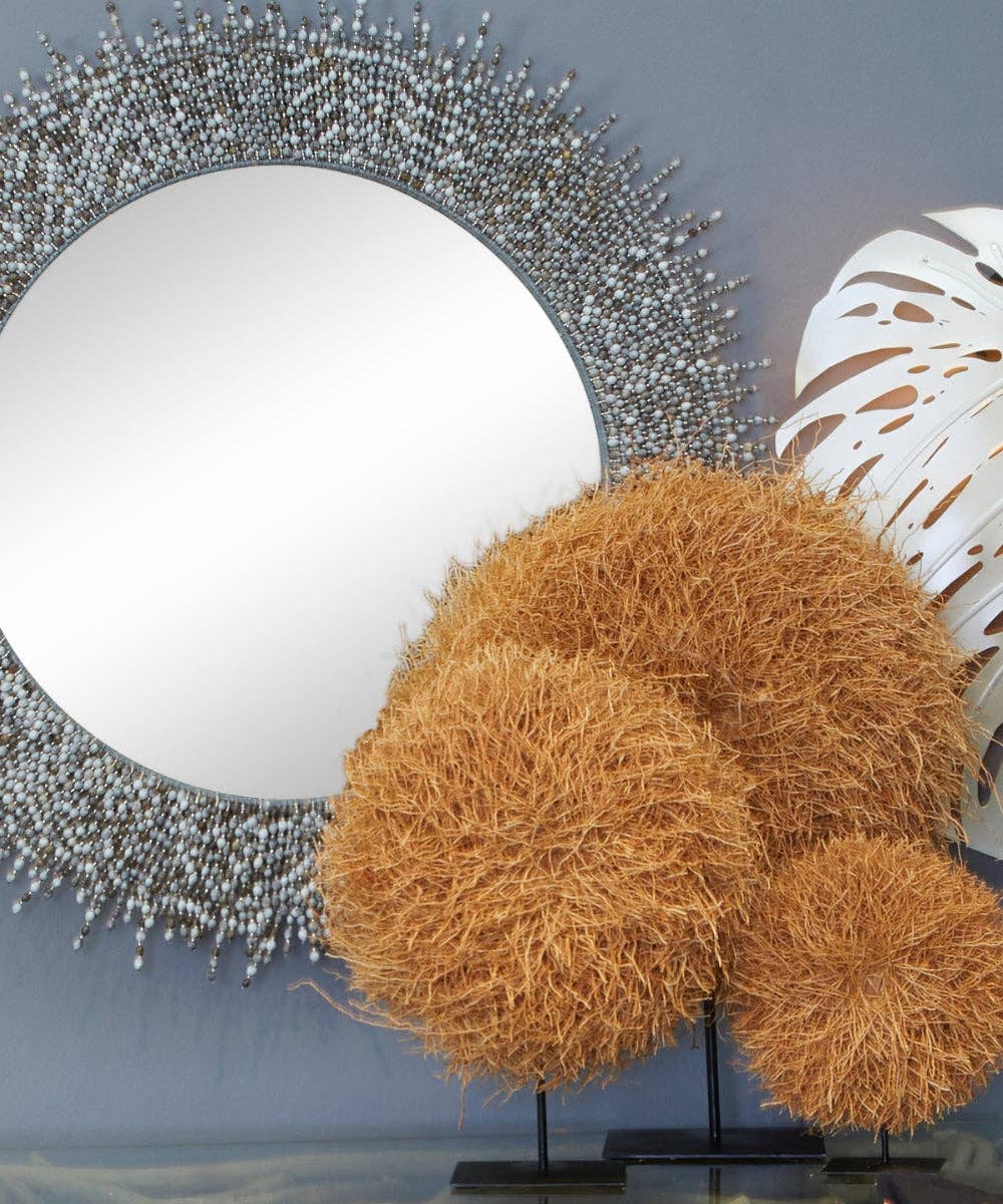 large decorative vetiver root nests on a reflective surface.