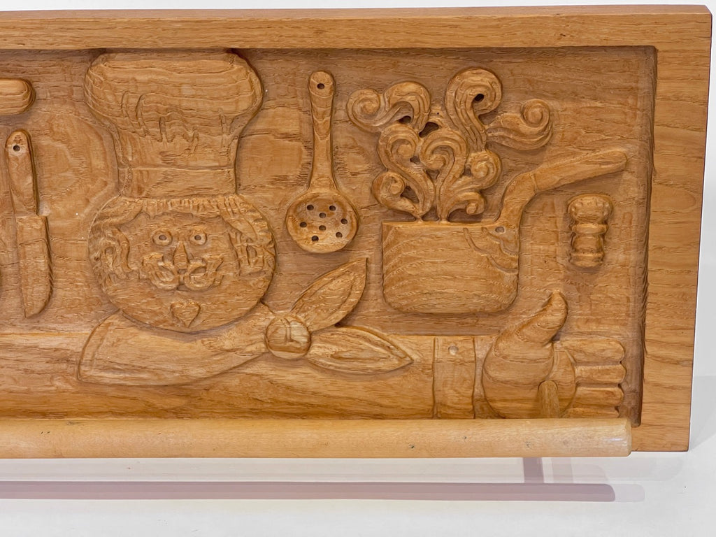 Wooden carving of kitchen utensils and items on a stand