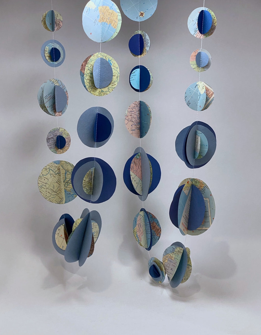 Decorative mobile with circular elements resembling planets or moons, garland made of paper