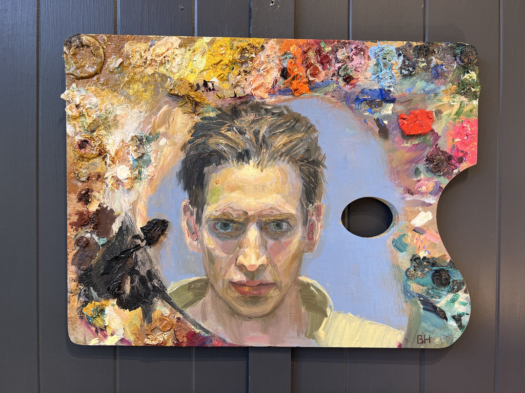 Artistic self-portrait on a paint palette with a dark background