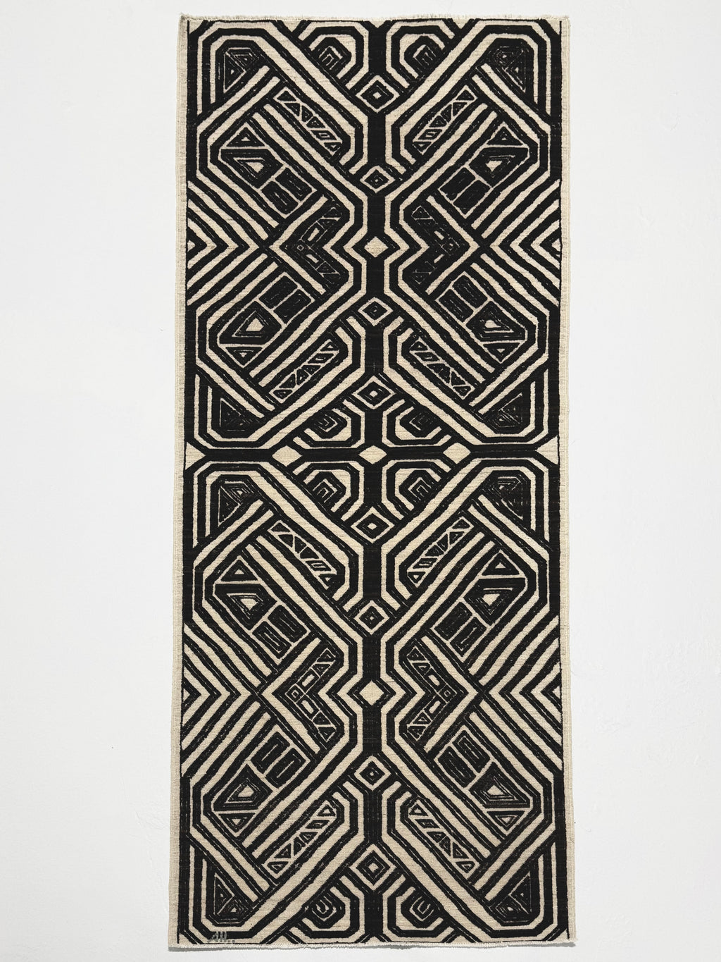 Black and white geometric patterned rug on a light gray background
