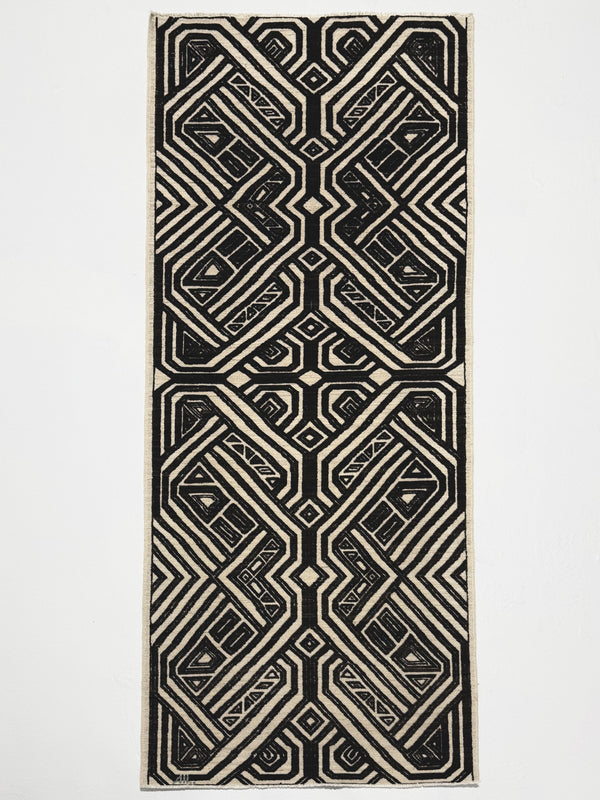 Black and white geometric patterned rug on a light gray background