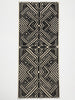 Black and white geometric patterned rug on a light gray background