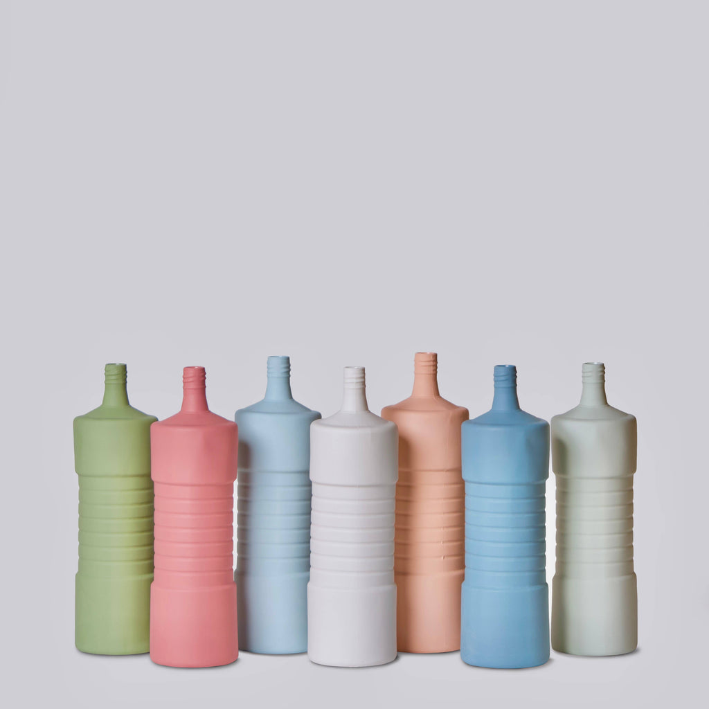 Set of colorful ceramic bottles on a light gray background