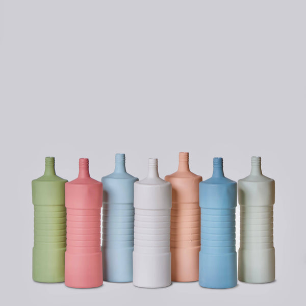 Set of colorful ceramic bottles on a light gray background