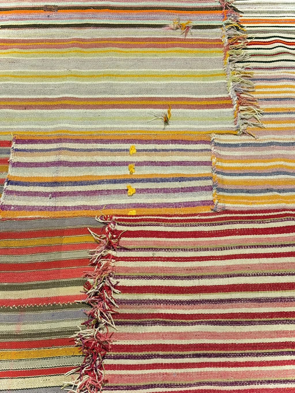 Striped rug with multicolor pattern and frayed edges