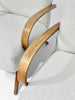 Close-up of a chair with wooden armrests and light gray cushioned backrest.