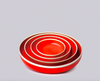 Set of red nesting bowls on a gray background