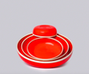 Set of red ceramic dishes with gold rims on a gray background